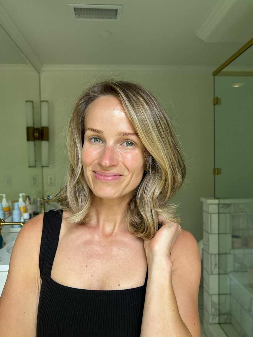 woman smiling and showing her face after doing her Skincare Routine