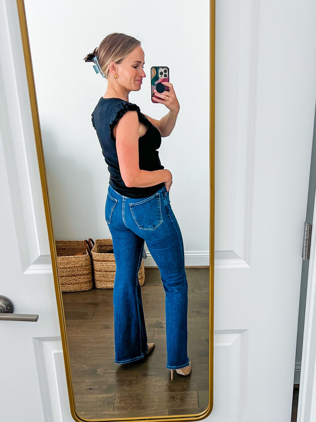 TeriLyn Adams showing the back details of the Ultra High Rise Flare Jean in black and dark blue wash