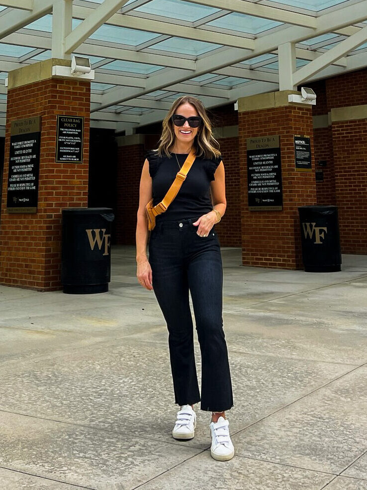 TeriLyn Adams wearing black top and black jeans one of the outfits for what to wear to a football game