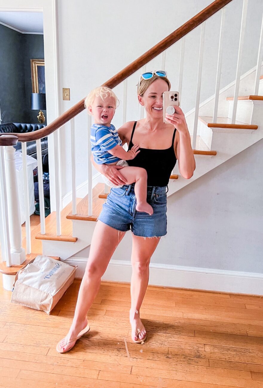Woman carrying her son in one of the best swimsuits for moms