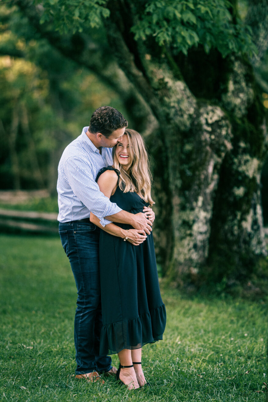 TeriLyn Adams taking a photo with her husband and wearing black dress and sharing Dresses for Fall Family Photos