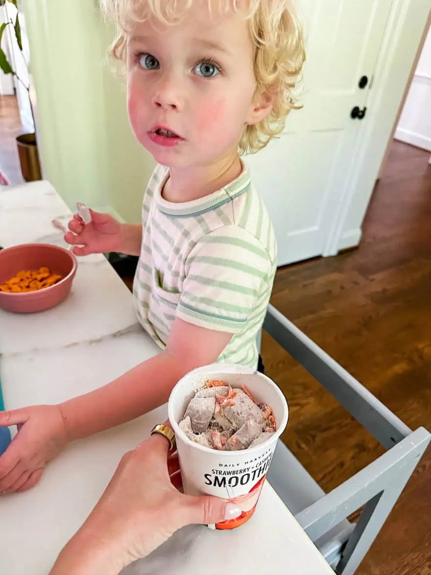 Woman handing toddler a Daily Harvest smoothie