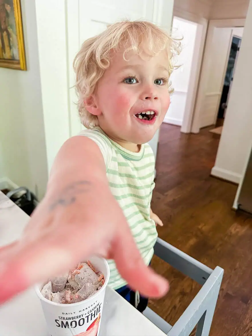 Toddler reaching for a Daily Harvest smoothie